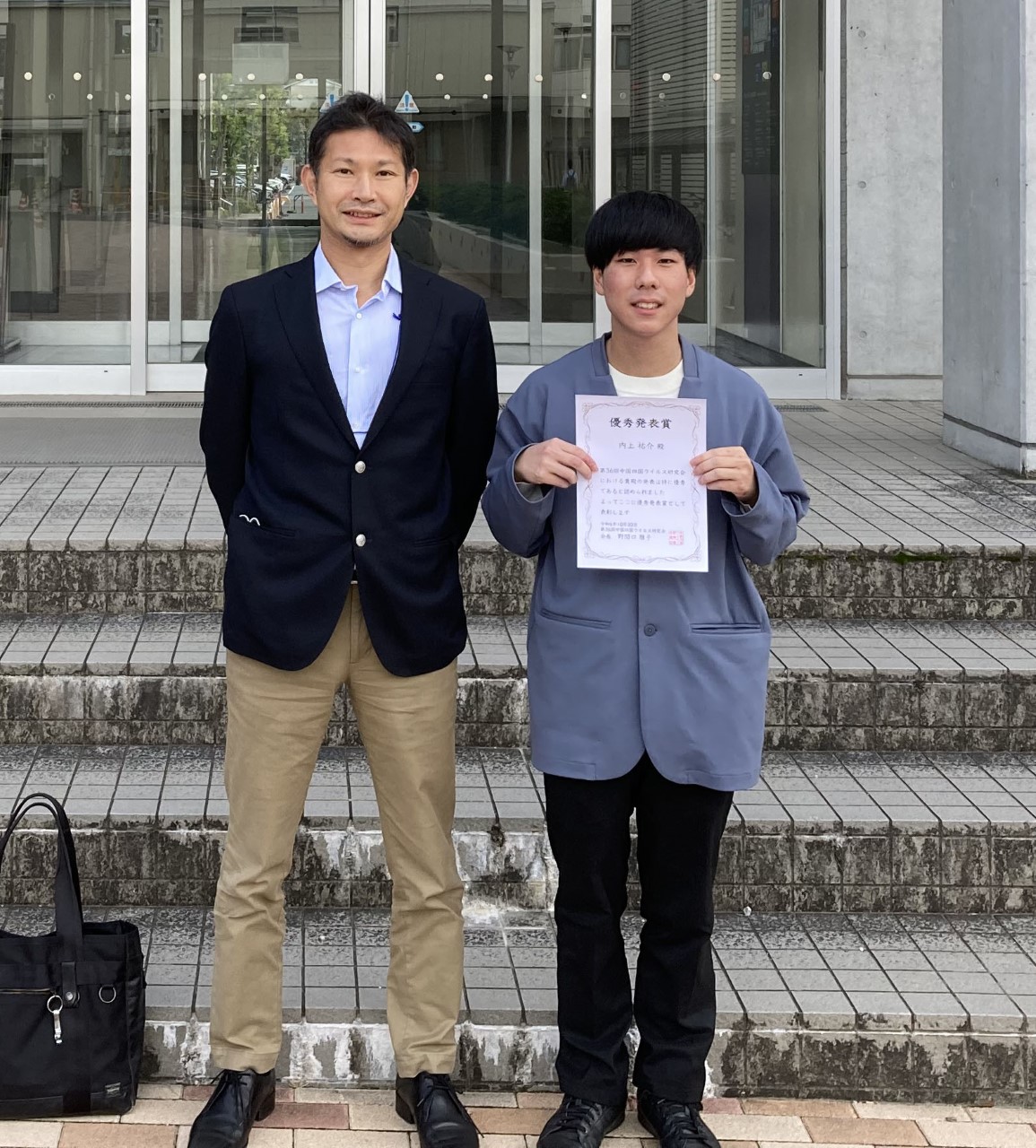 イメージ：指導教員の高橋宏隆准教授（左）と受賞した内上祐介さん（右）