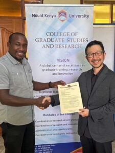 ヤッチ ヘンリー博士（マウントケニア大学 高等教育研究学部長）と高島准教授が握手している写真