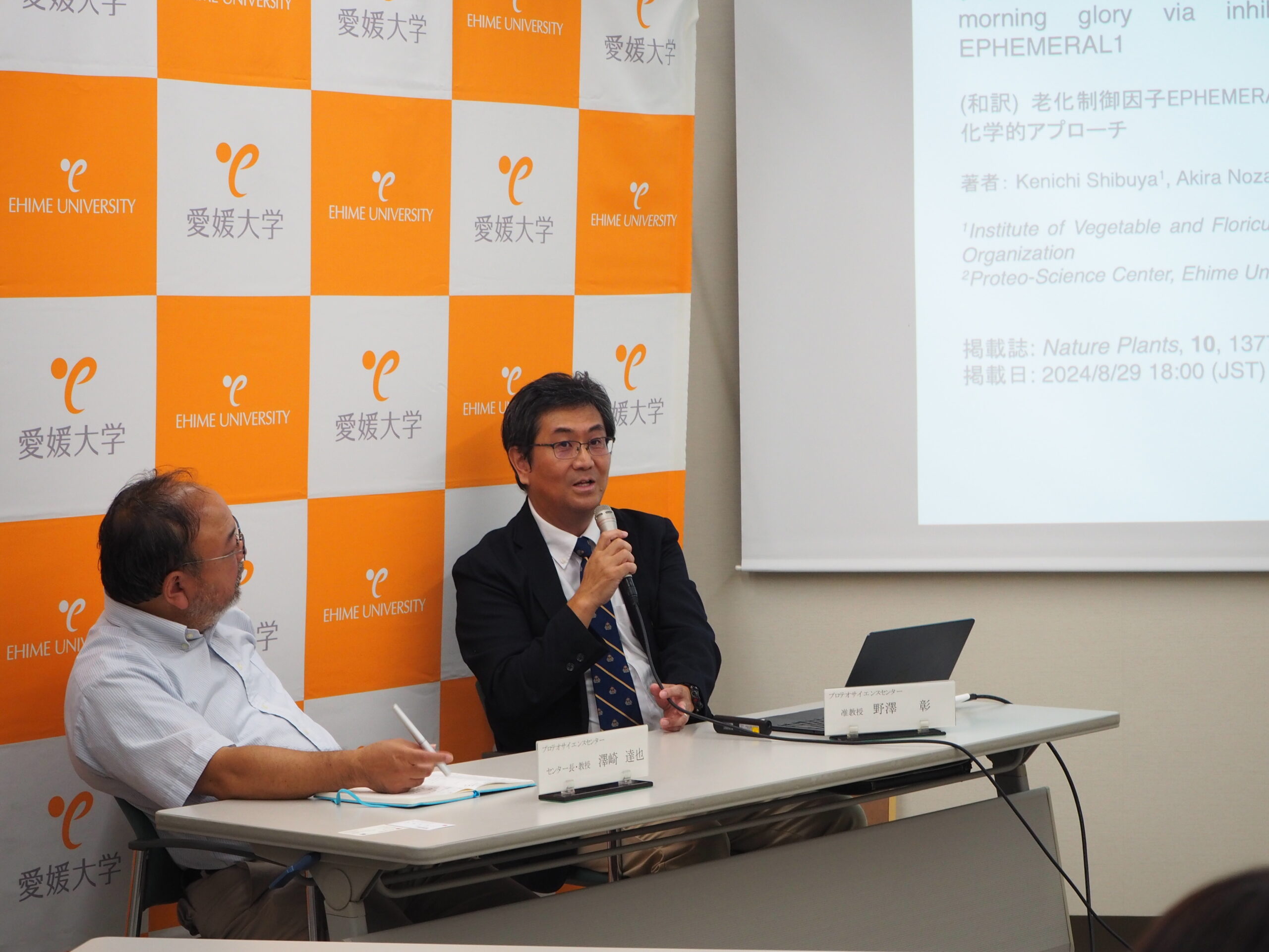 イメージ：記者説明会で質問に答える野澤准教授（右）と澤崎 達也プロテオサイエンスセンター長